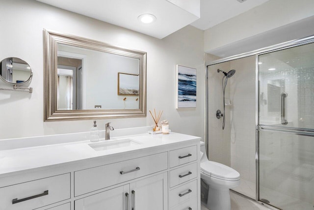 bathroom featuring toilet, vanity, and walk in shower