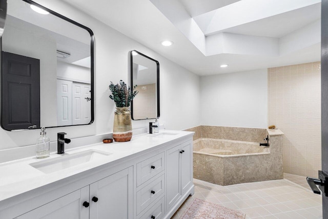 bathroom with a relaxing tiled tub, tile patterned flooring, and vanity