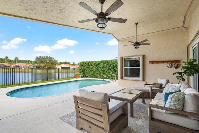 view of pool with outdoor lounge area, a patio, ceiling fan, and a water view