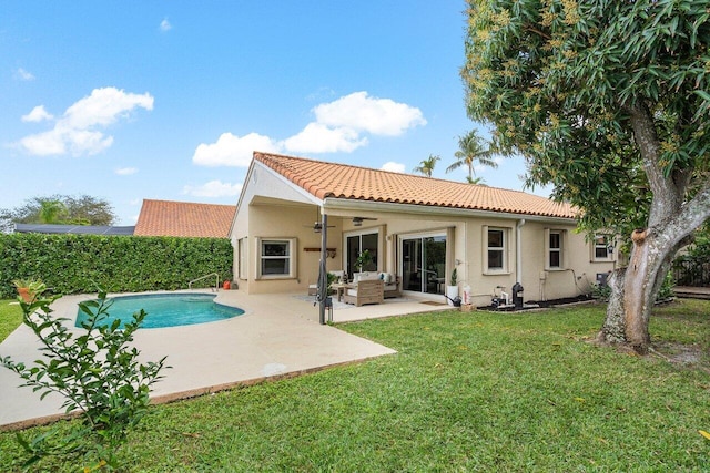 back of property featuring a yard, ceiling fan, a patio, a fenced in pool, and an outdoor living space