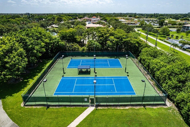 view of sport court featuring a lawn