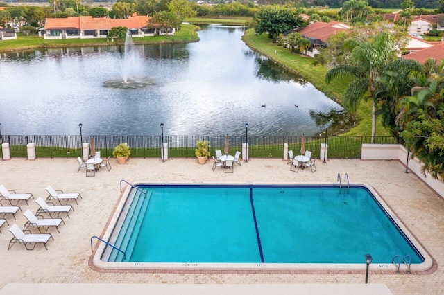 view of pool with a water view and a patio area