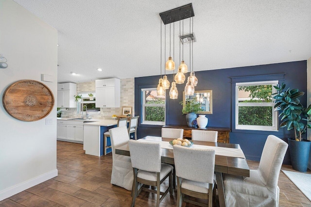 dining space featuring a textured ceiling, a wealth of natural light, and sink