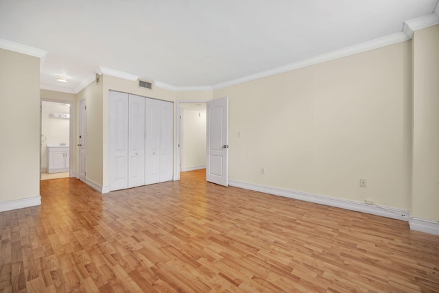 unfurnished bedroom featuring a closet, ornamental molding, and light hardwood / wood-style floors