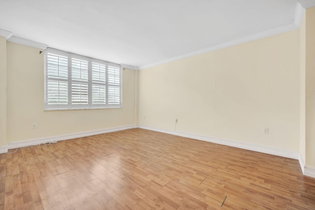 empty room featuring crown molding and light hardwood / wood-style flooring