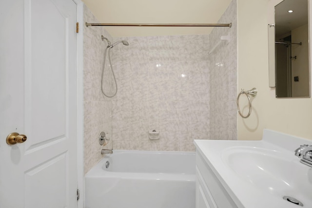 bathroom featuring tiled shower / bath combo and vanity