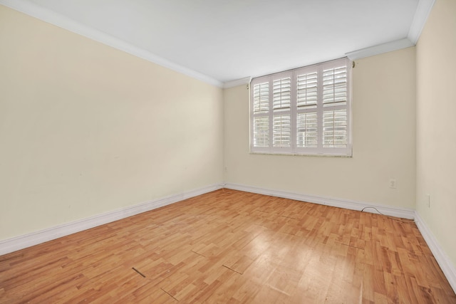 empty room with light wood-type flooring and crown molding