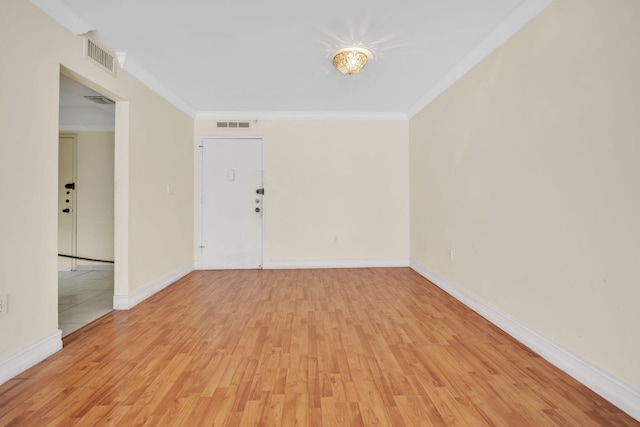 spare room featuring light hardwood / wood-style flooring and crown molding