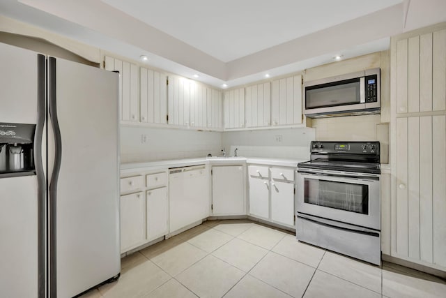 kitchen featuring stainless steel appliances, white cabinetry, and light tile patterned floors