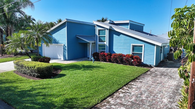 view of front of property with central AC, a garage, and a front lawn