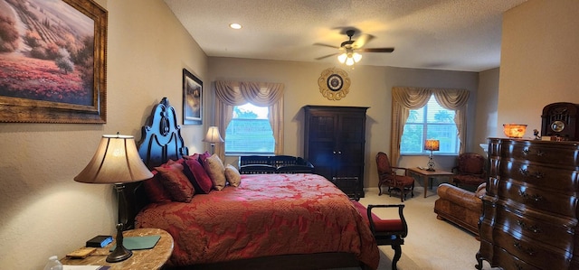 carpeted bedroom featuring a textured ceiling and a ceiling fan