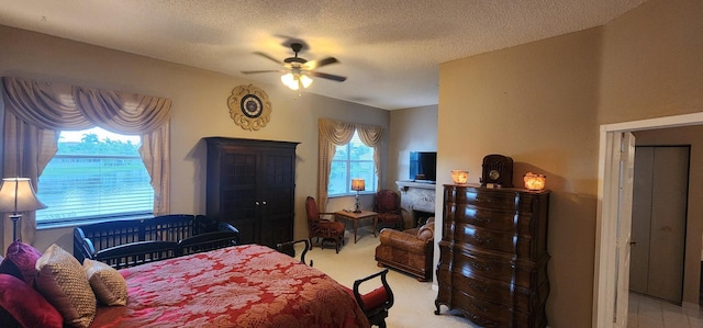 bedroom with ceiling fan and a textured ceiling