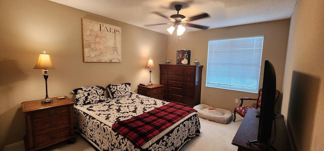 bedroom featuring a textured ceiling, ceiling fan, and light carpet