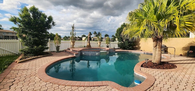view of swimming pool with a pool with connected hot tub, a fenced backyard, and a patio area