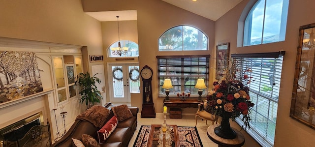 tiled entryway featuring a chandelier, high vaulted ceiling, and baseboards