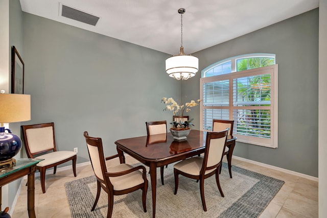 tiled dining space with an inviting chandelier