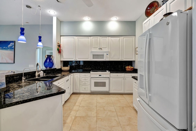 kitchen featuring light tile patterned flooring, white cabinetry, decorative light fixtures, dark stone countertops, and white appliances