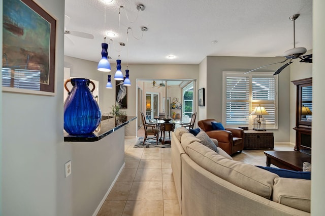 tiled living room with a textured ceiling and ceiling fan