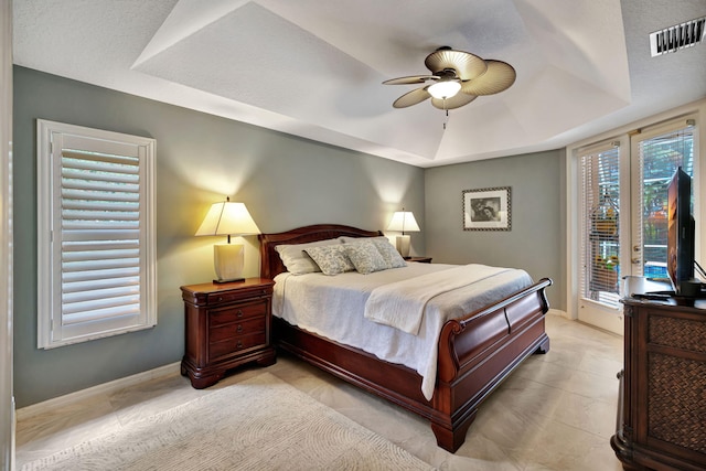 bedroom with a raised ceiling, access to exterior, and ceiling fan