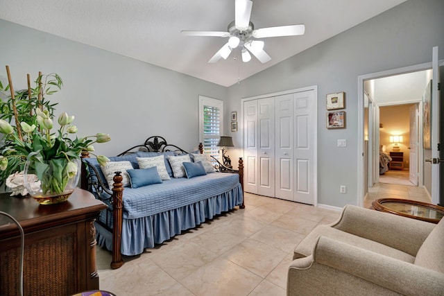 bedroom with light tile patterned flooring, lofted ceiling, ceiling fan, and a closet