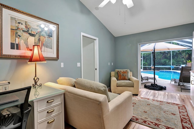 living room with lofted ceiling, ceiling fan, and light wood-type flooring