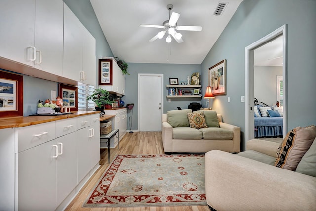 living room featuring ceiling fan, vaulted ceiling, and light hardwood / wood-style flooring