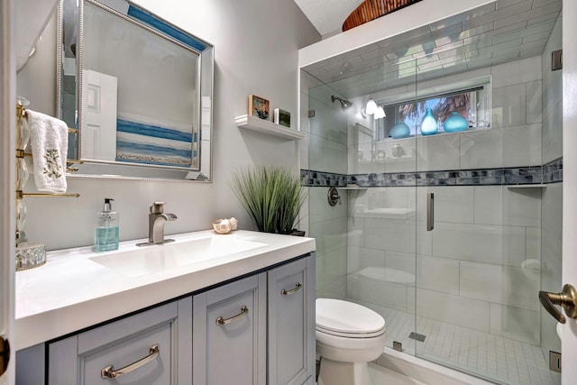 bathroom with vanity, toilet, and a shower with door