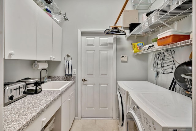 clothes washing area featuring cabinets, light tile patterned flooring, sink, and washer and clothes dryer