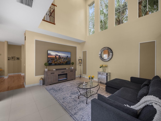 living room with tile patterned flooring and a towering ceiling