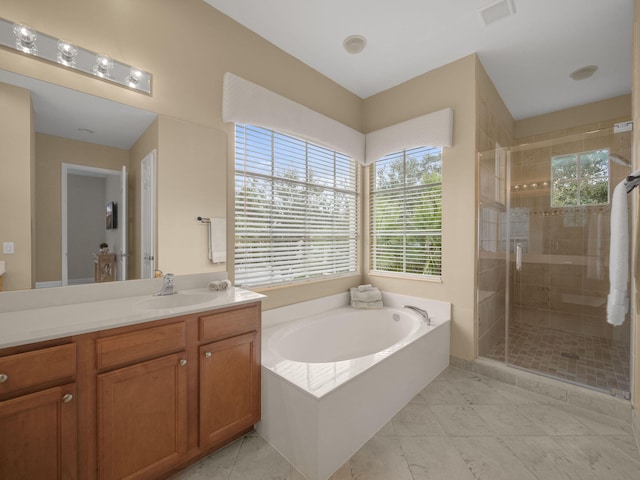 bathroom with shower with separate bathtub, vanity, and tile patterned floors