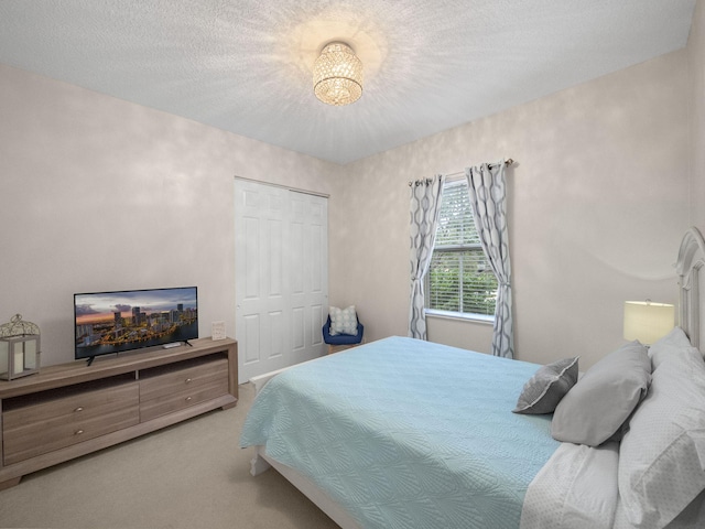 carpeted bedroom with a textured ceiling and a closet