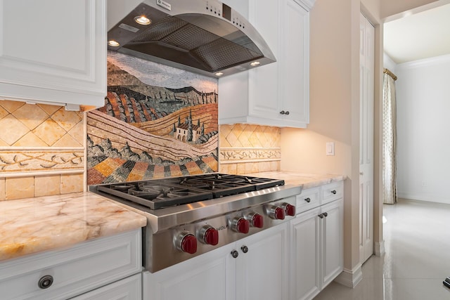 kitchen with light stone countertops, premium range hood, stainless steel gas cooktop, and white cabinets