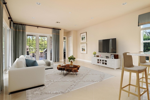 living room featuring french doors and light tile patterned floors