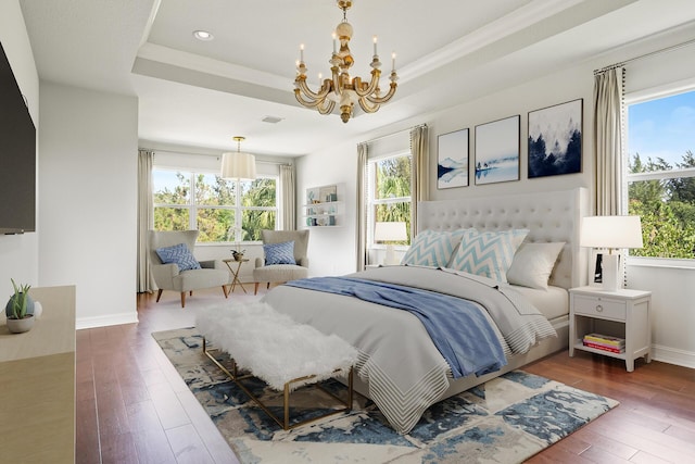 bedroom featuring a raised ceiling, a chandelier, and dark hardwood / wood-style flooring