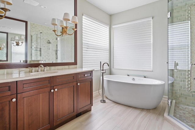 bathroom with vanity, an inviting chandelier, and plus walk in shower