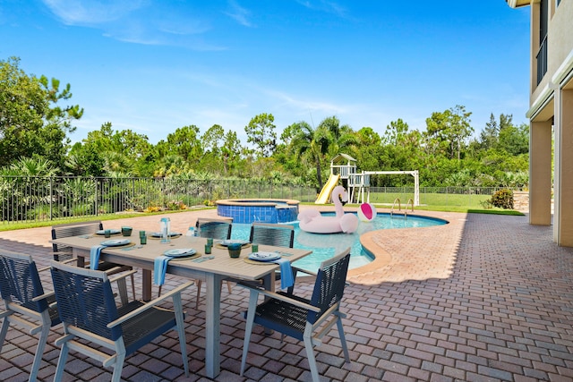 view of patio featuring a pool with hot tub and a playground