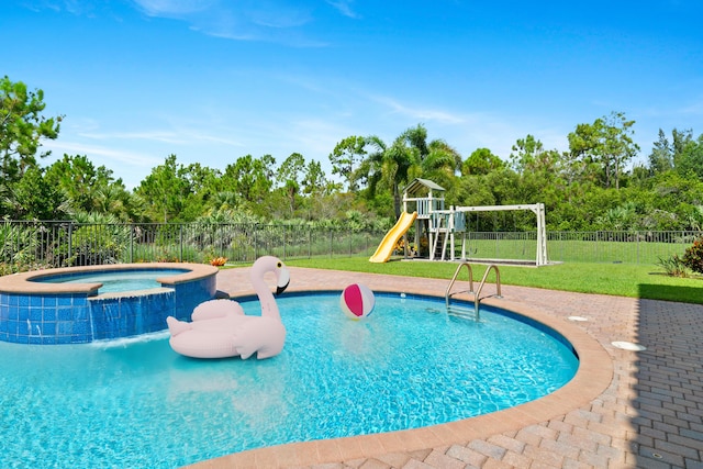 view of pool with a playground, an in ground hot tub, and a lawn