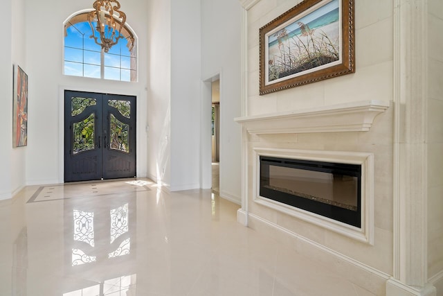 foyer entrance with a high ceiling, french doors, tile patterned flooring, and a wealth of natural light