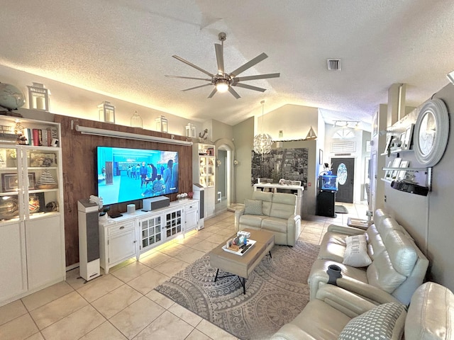 tiled living room featuring vaulted ceiling, ceiling fan, and a textured ceiling