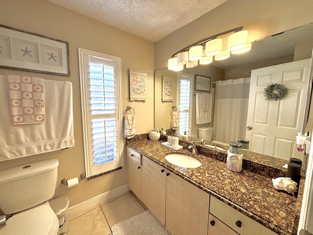 bathroom with tile patterned flooring, vanity, a textured ceiling, toilet, and walk in shower