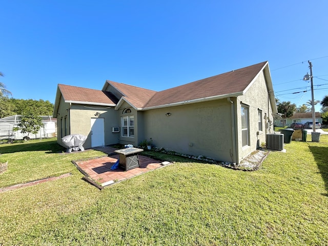 rear view of property featuring cooling unit, a lawn, and a patio