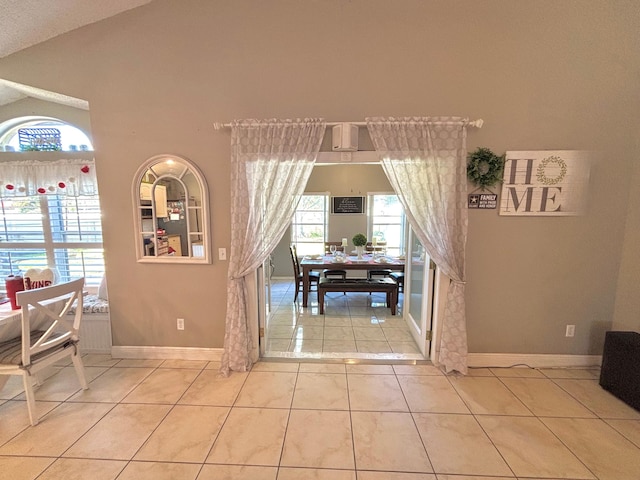 dining room with light tile patterned flooring and vaulted ceiling