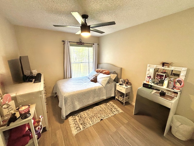 bedroom featuring ceiling fan, light hardwood / wood-style flooring, and a textured ceiling