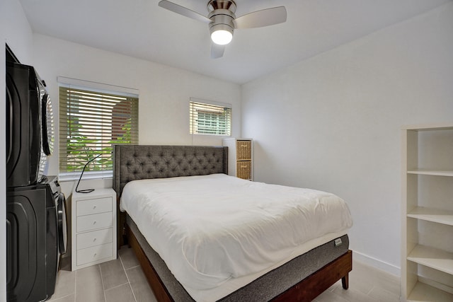 bedroom with stacked washer and clothes dryer and ceiling fan