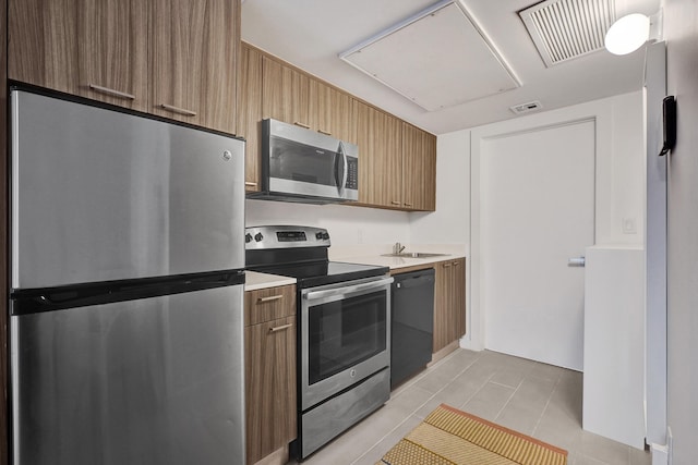 kitchen featuring sink, light tile patterned floors, and appliances with stainless steel finishes