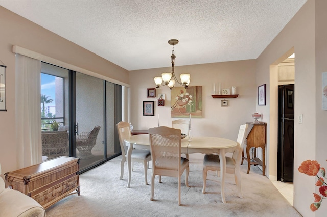 dining area featuring light carpet, a textured ceiling, and a notable chandelier