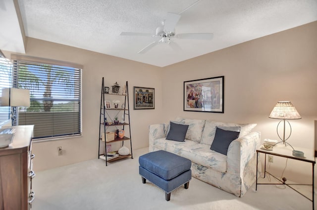 carpeted living room with a textured ceiling and ceiling fan