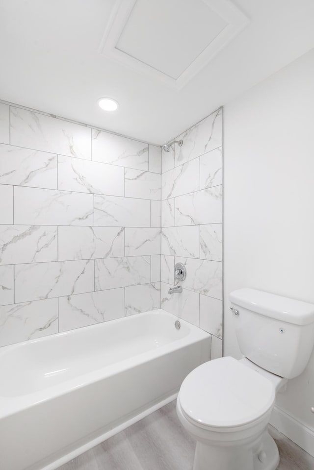 bathroom featuring toilet, hardwood / wood-style flooring, and tiled shower / bath