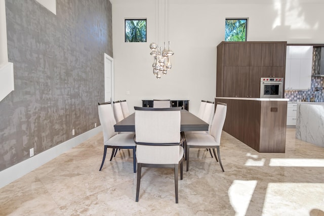 dining space with a towering ceiling and an inviting chandelier