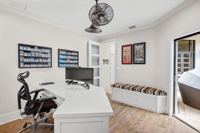 home office featuring light hardwood / wood-style floors and crown molding